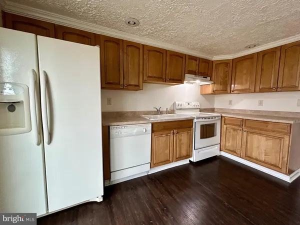 a kitchen with a sink a refrigerator and cabinets