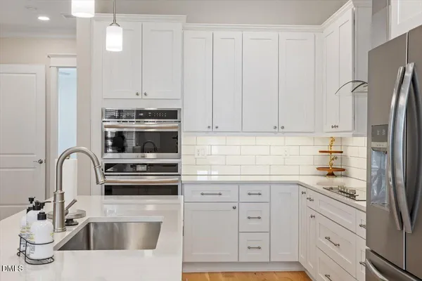 a kitchen with a sink a kitchen island and stainless steel appliances