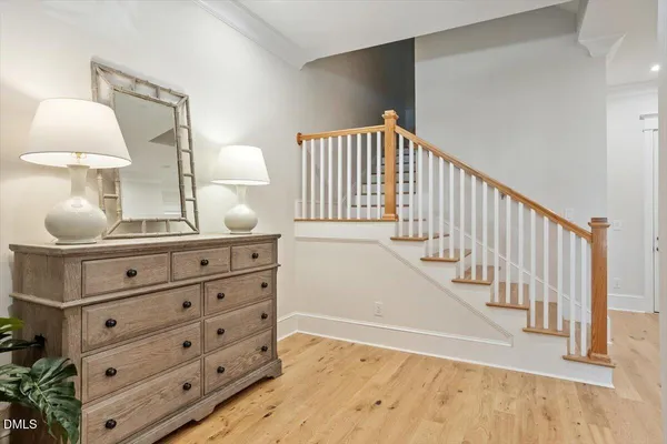 a view of a hallway to room with cabinet and lamp