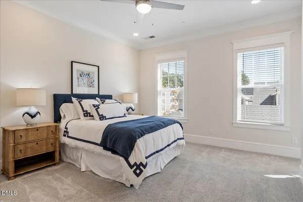a spacious bedroom with a large bed and a chandelier