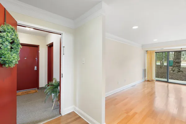 a view of an empty room with wooden floor and a window