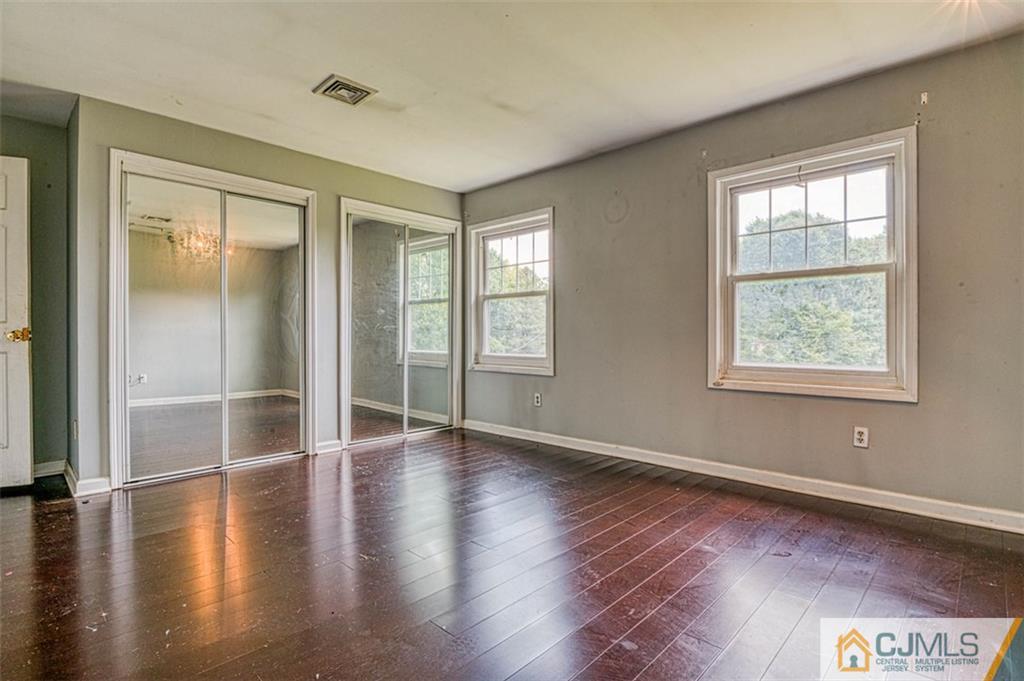 207 Fresh Ponds Road Monroe Township, NJ 08831 - Photo 23 of 25 an empty room with wooden floor and windows