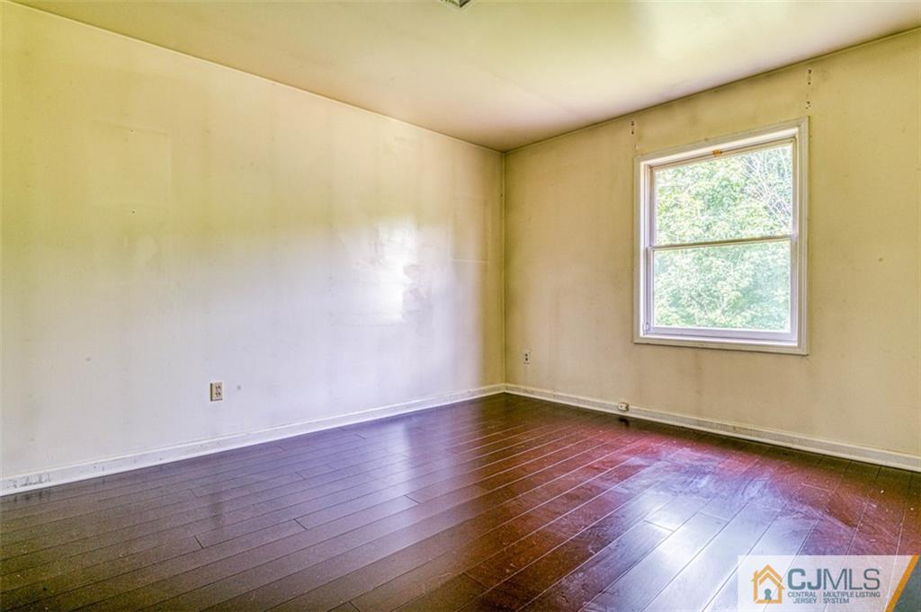 207 Fresh Ponds Road Monroe Township, NJ 08831 - Photo 24 of 25 a view of an empty room with wooden floor and a window
