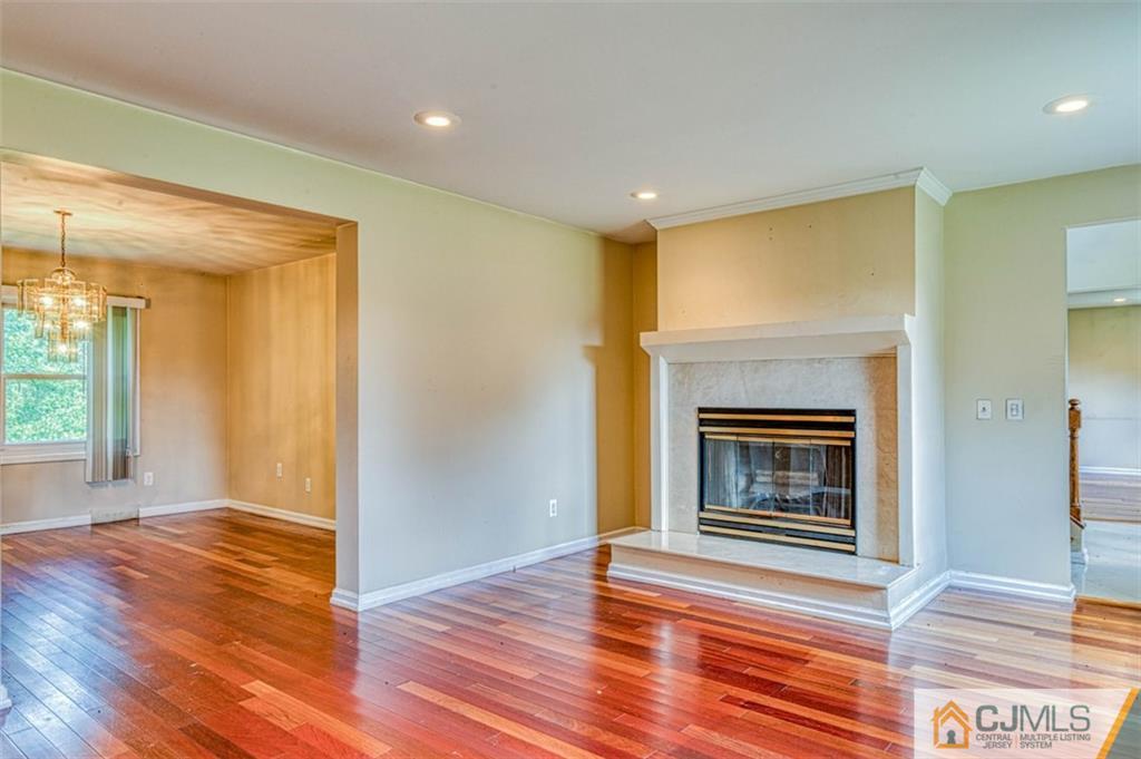 207 Fresh Ponds Road Monroe Township, NJ 08831 - Photo 7 of 25 a view of empty room with wooden floor and fireplace