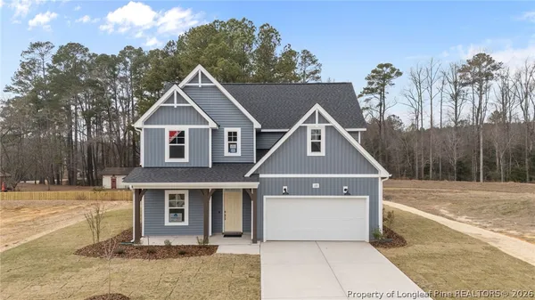 a front view of a house with a yard and trees