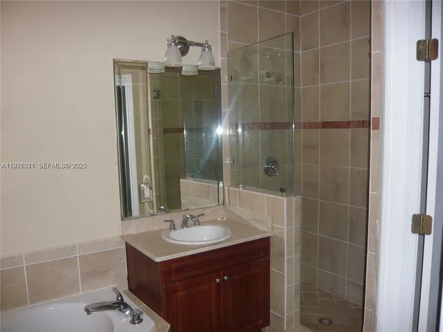 a bathroom with a sink shower and a mirror