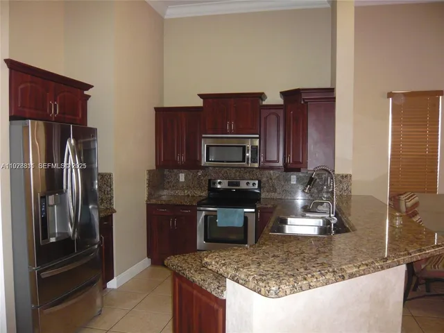 a kitchen with stainless steel appliances granite countertop a refrigerator and a stove