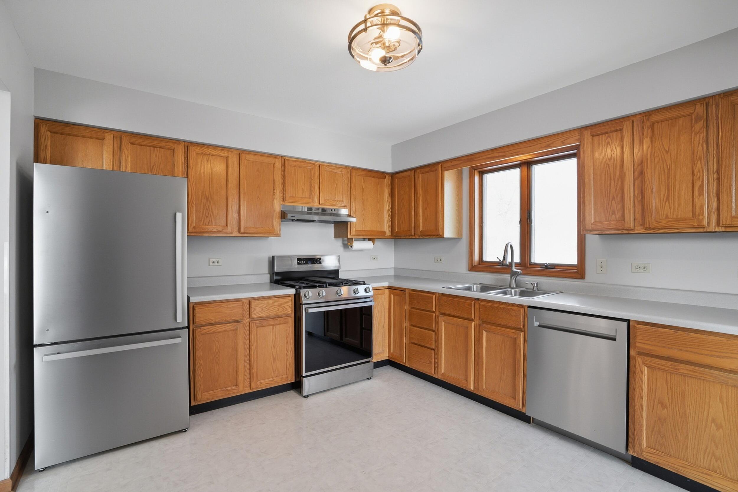 5125 Cardinal Court Schererville, IN 46375 - Photo 9 of 27 a kitchen with stainless steel appliances granite countertop a refrigerator a sink a stove a washer and cabinets