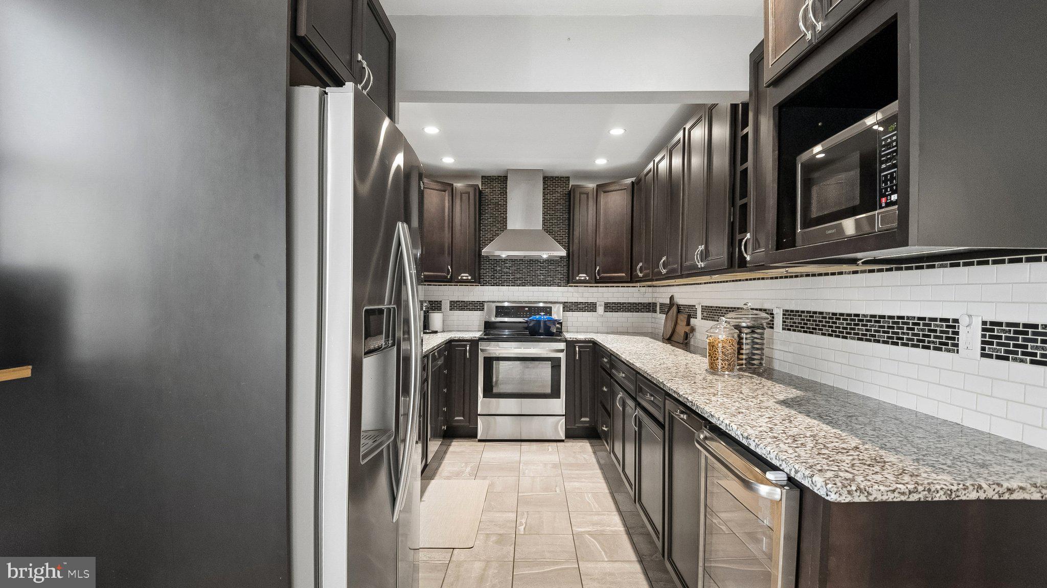 629 Willowbrook Road Havertown, PA 19083 - Photo 15 of 33 a kitchen with stainless steel appliances granite countertop a stove a sink and a microwave