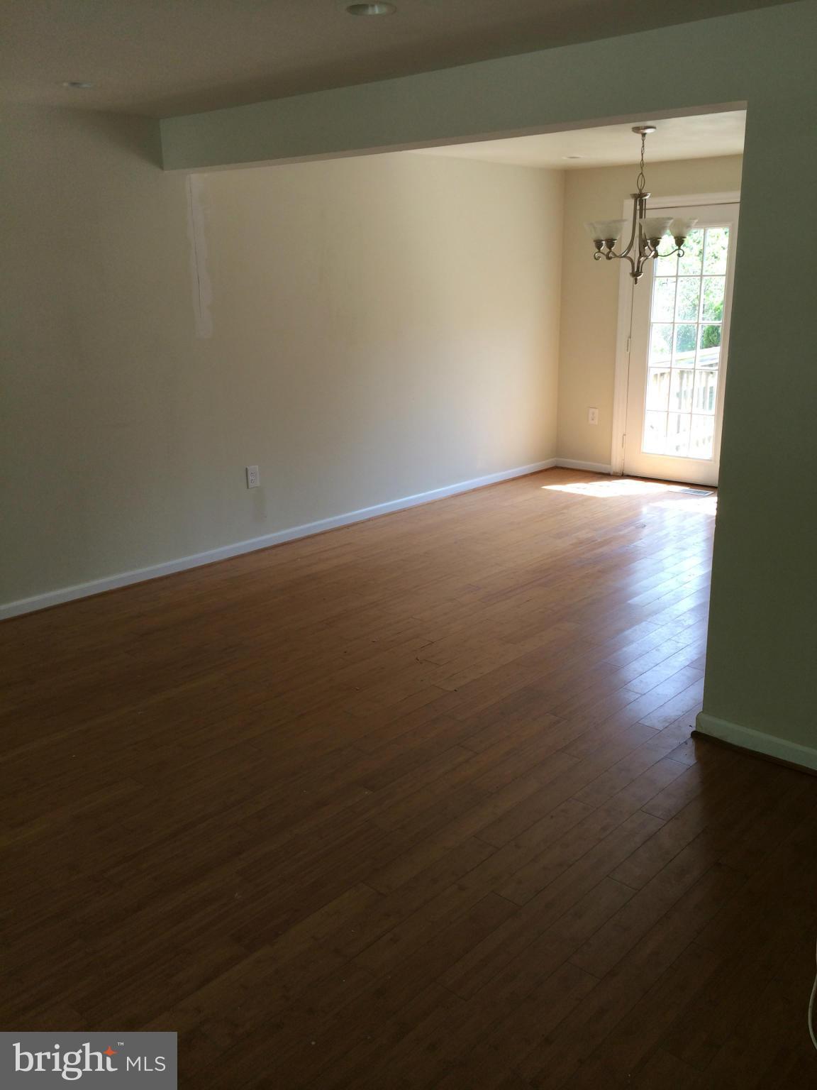 3513 Chado Road Clinton, MD 20735 - Photo 3 of 6 an empty room with wooden floor and windows with curtains