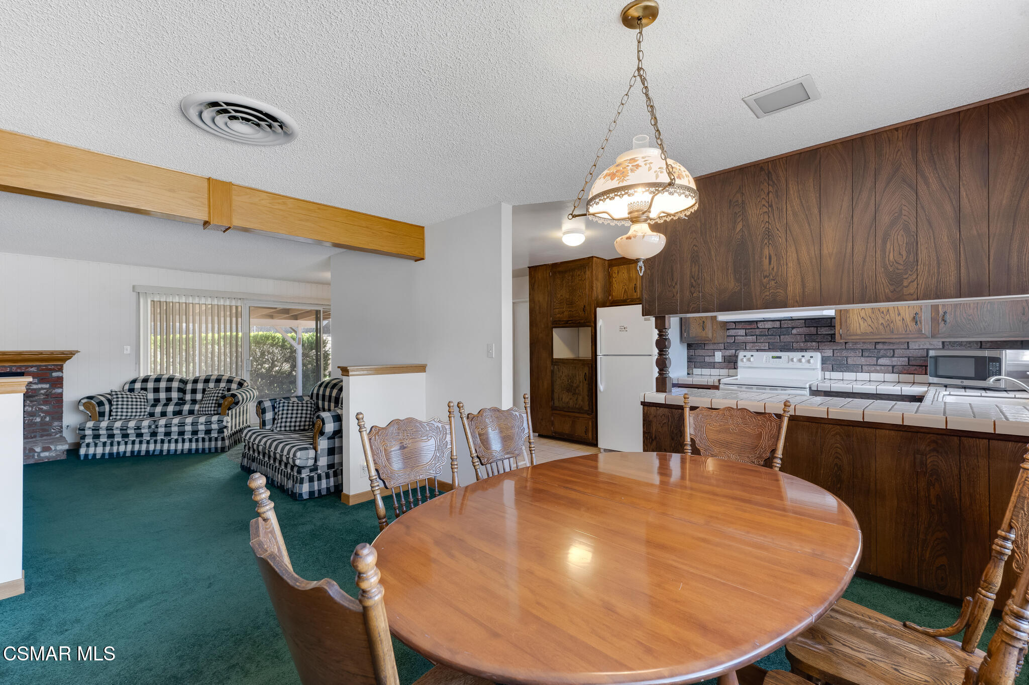 3493 Amarillo Avenue Simi Valley, CA 93063 - Photo 12 of 49 a dining room with wooden floor a chandelier a wooden table and chairs