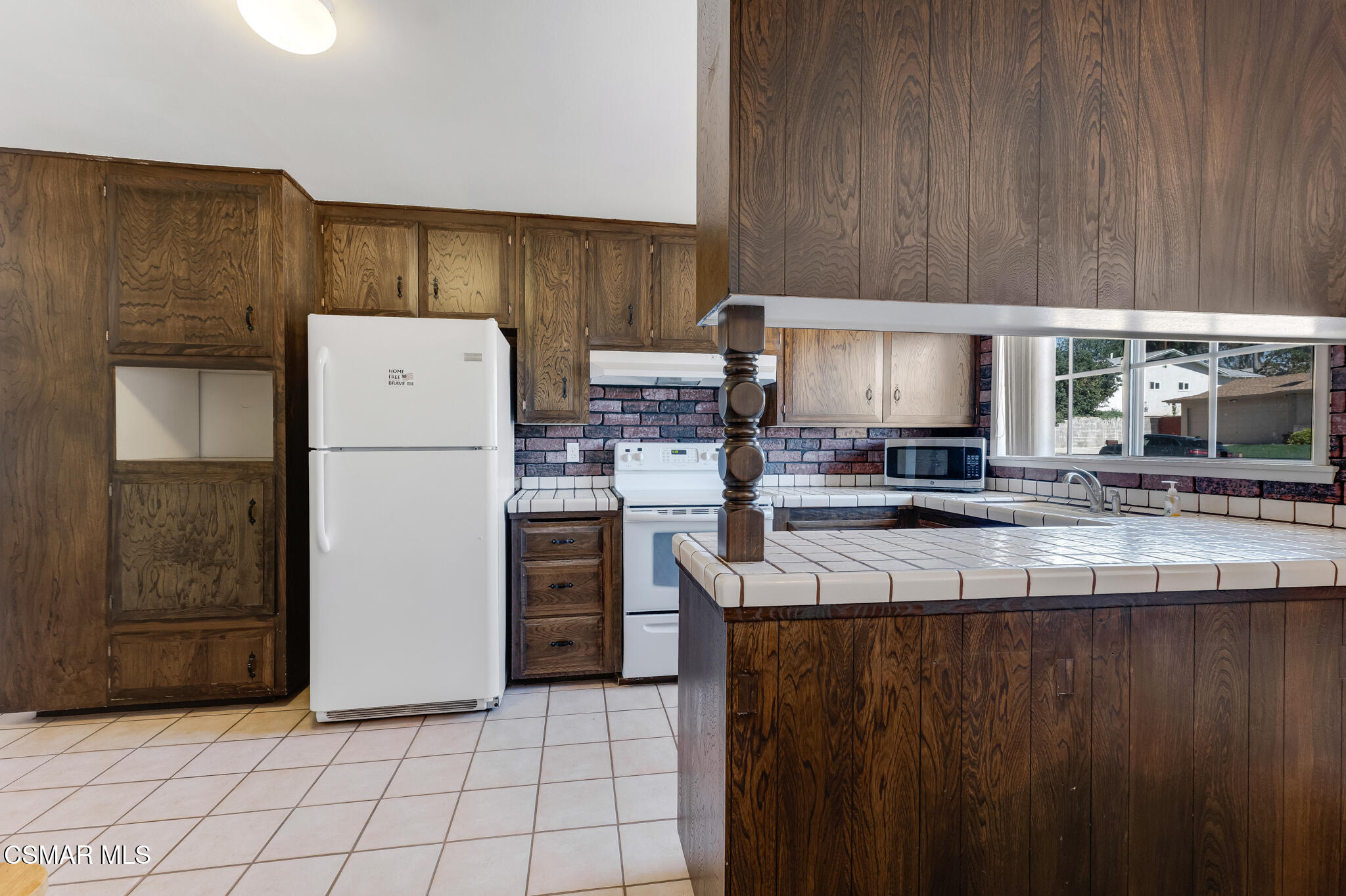 3493 Amarillo Avenue Simi Valley, CA 93063 - Photo 13 of 49 a kitchen with a refrigerator a stove and a wooden cabinets