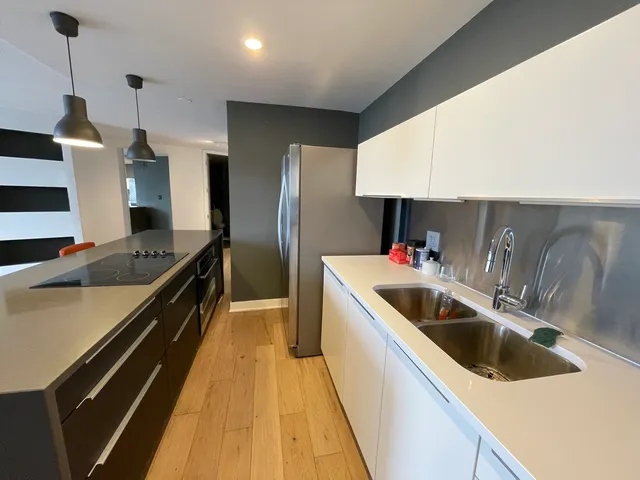 a kitchen with a sink a counter top space a stove and refrigerator