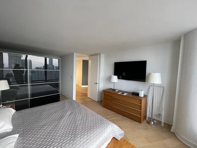 a bedroom with furniture and flat screen tv
