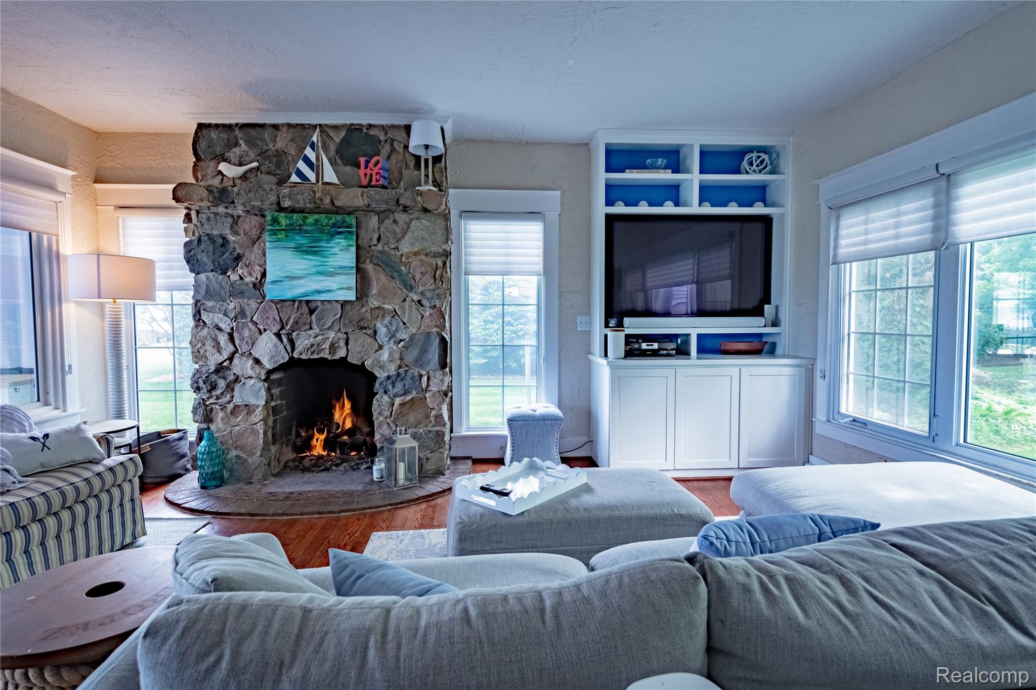 5630 Lakeshore Road Fort Gratiot, MI 48059 - Photo 13 of 49 Stone-faced fireplace with a hearth, flanked by multiple windows