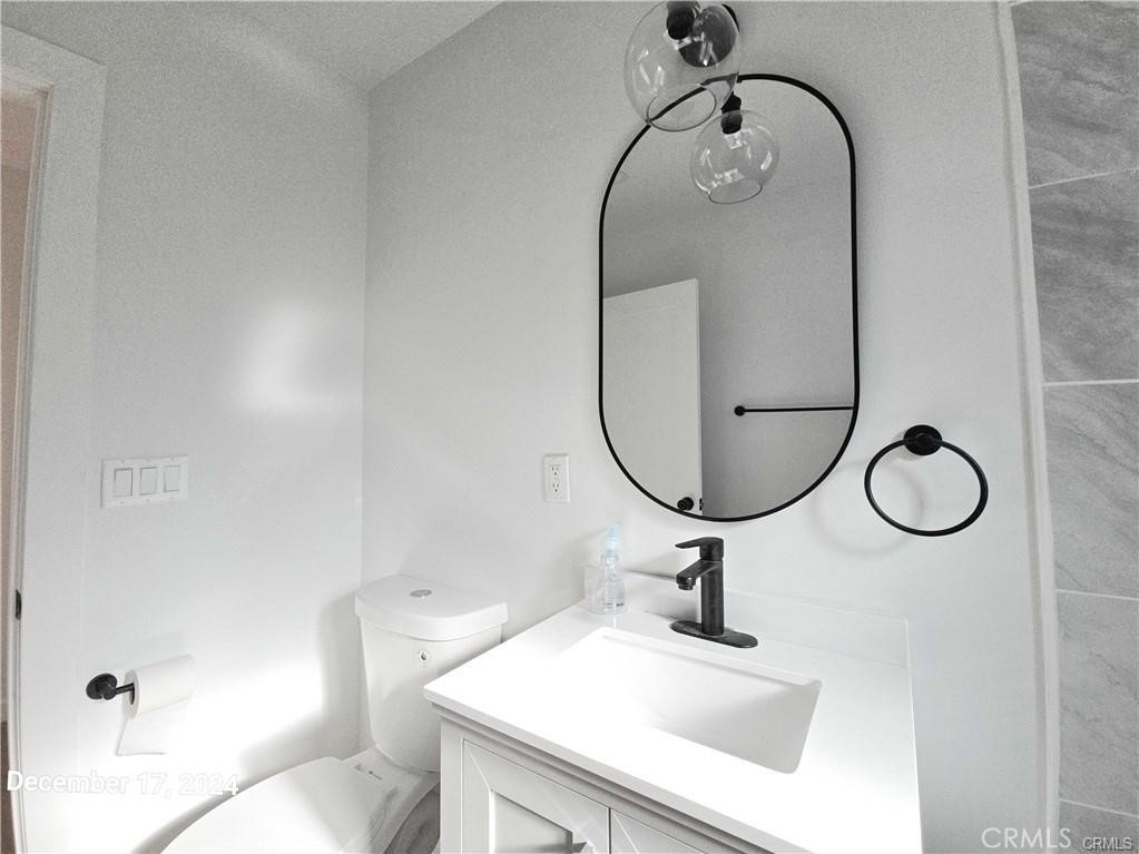 11171 Bullis Road Lynwood, CA 90262 - Photo 14 of 15 a bathroom with a sink a toilet and a mirror