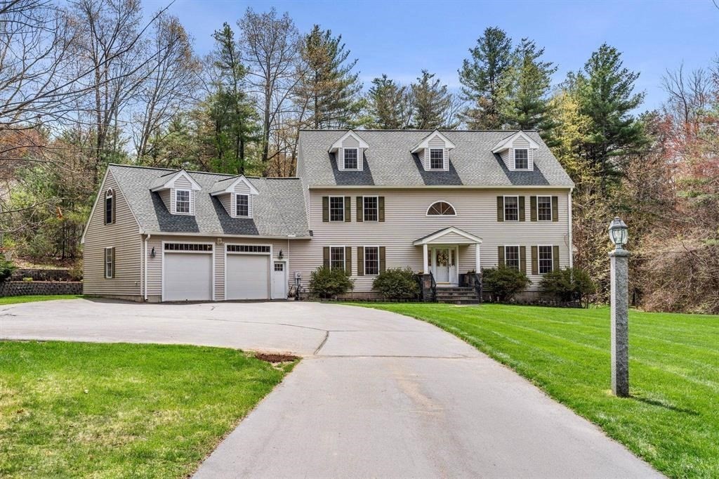 15 Lamb Road Nashua, NH 03062 - Photo 1 of 40 a front view of a house with a garden and trees