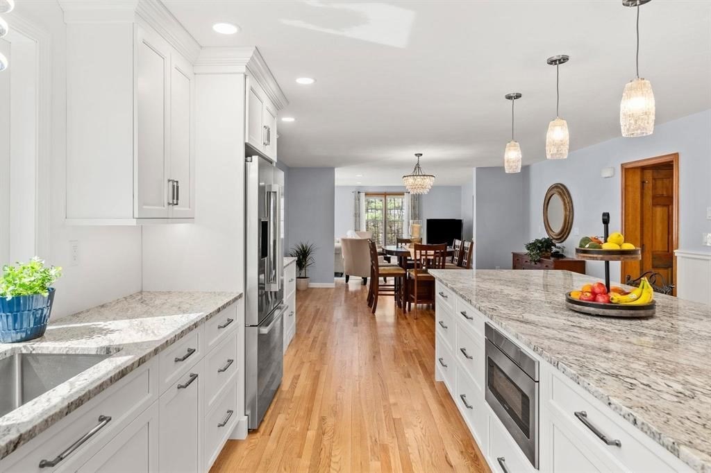 15 Lamb Road Nashua, NH 03062 - Photo 6 of 40 a large kitchen with kitchen island a large counter space a sink appliances and living room view