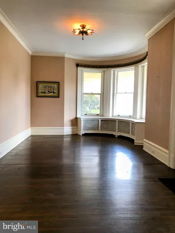 a view of a livingroom with wooden floor and a fireplace
