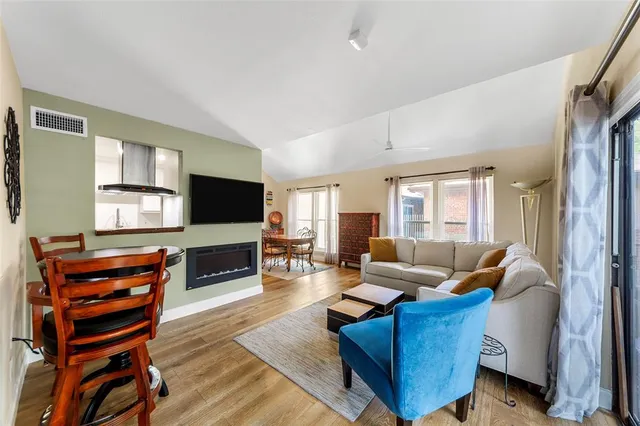 a living room with furniture a flat screen tv and a fireplace