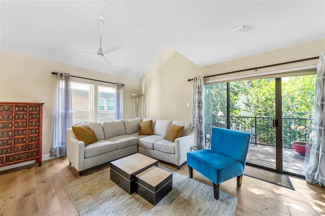 a living room with furniture a lamp and a floor to ceiling window