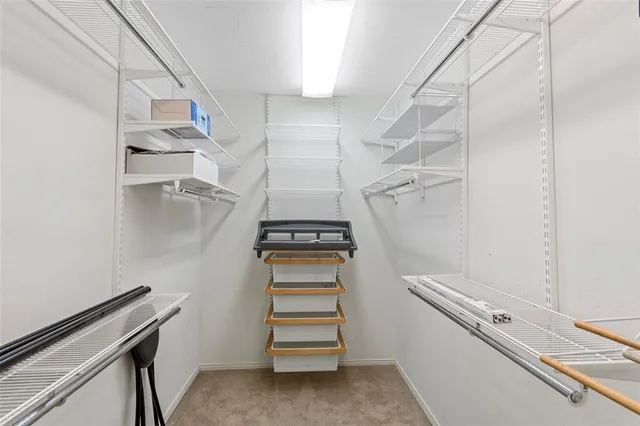 a view of walk in closet with empty racks