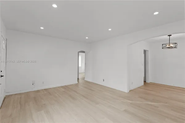 an empty room with wooden floor and ceiling fan