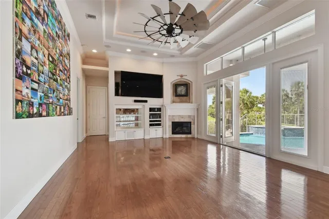 a view of a hallway with wooden floor and a living room