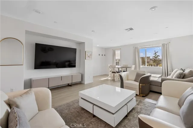 a living room with furniture a flat screen tv and a window