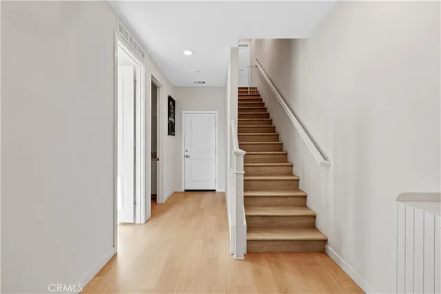 a view of a hallway with wooden floor and entryway