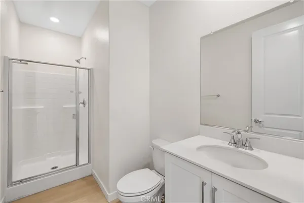 a bathroom with a granite countertop sink toilet a mirror a vanity and shower
