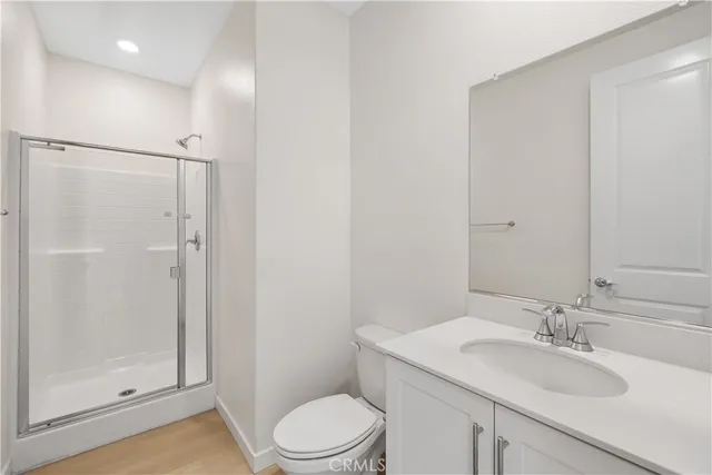 a bathroom with a granite countertop sink toilet a mirror a vanity and shower
