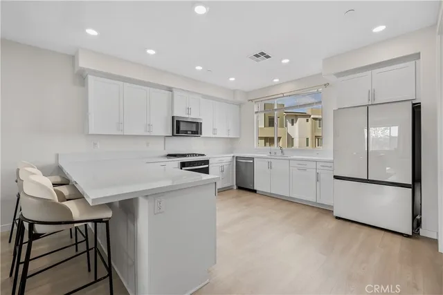 a kitchen with white cabinets and stainless steel appliances