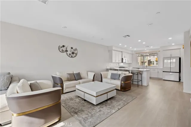 a living room with furniture and view of kitchen