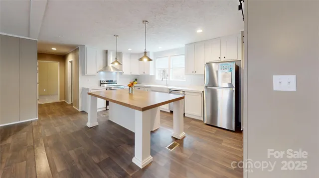 a kitchen with a sink a refrigerator and wooden floor