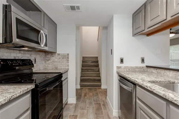 a kitchen with stainless steel appliances granite countertop a stove and a microwave