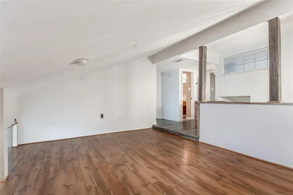 a view of a room with wooden floor and a window
