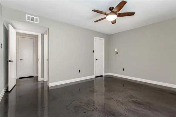 an empty room with closet and a ceiling fan
