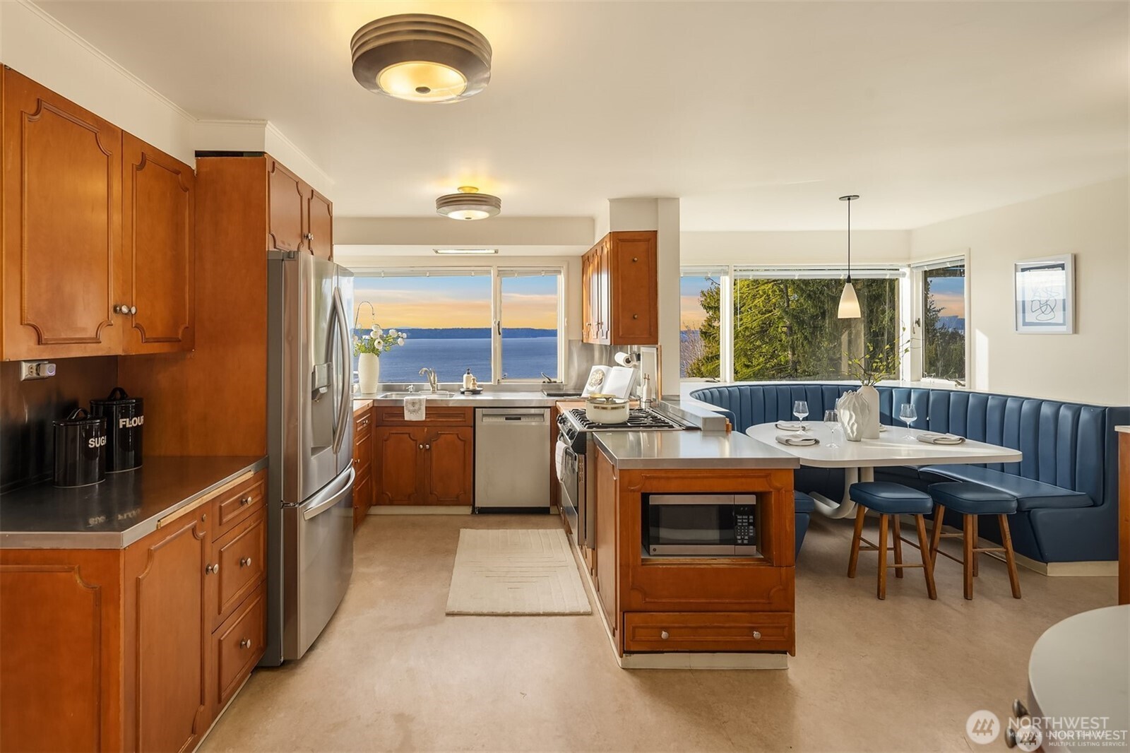 727 Southwest 199th Place Normandy Park, WA 98166 - Photo 13 of 38 a kitchen with kitchen island a stove a sink a dining table and chairs