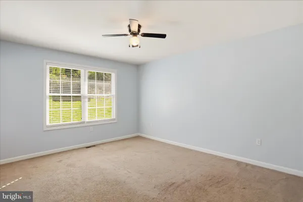 an empty room with closet and fan