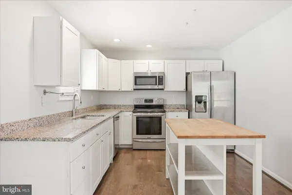 a kitchen with a refrigerator a sink and a stove top oven
