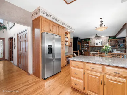 a kitchen with stainless steel appliances granite countertop a refrigerator a sink and a stove