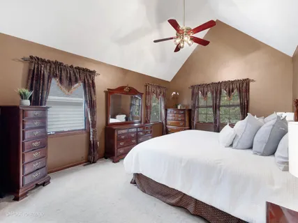 a bedroom with a bed and a ceiling fan
