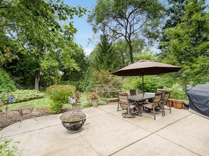 a view of a backyard with table and chairs under an umbrella