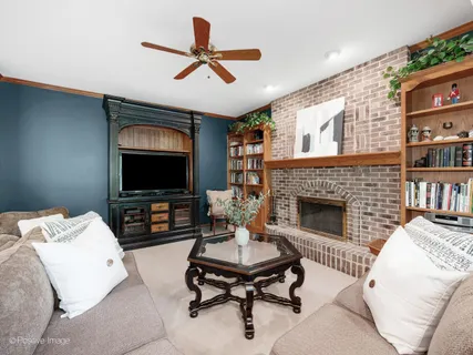 a living room with furniture a flat screen tv and a fireplace