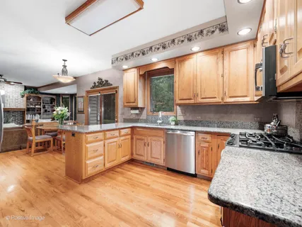 a kitchen with stainless steel appliances granite countertop a sink counter space cabinets and a large window