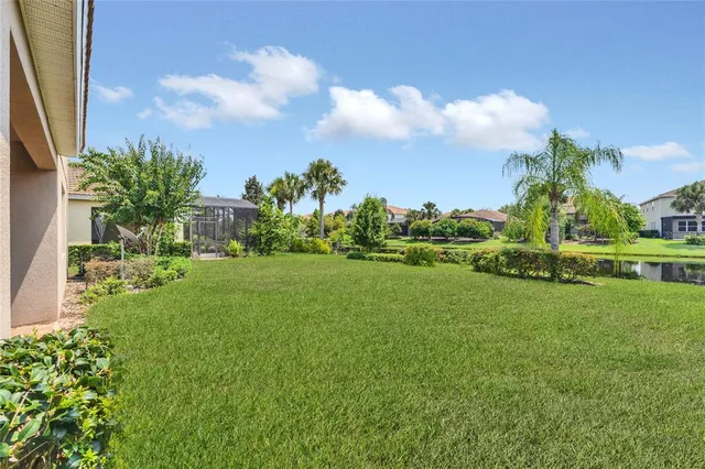 a view of a green field with tree in the background
