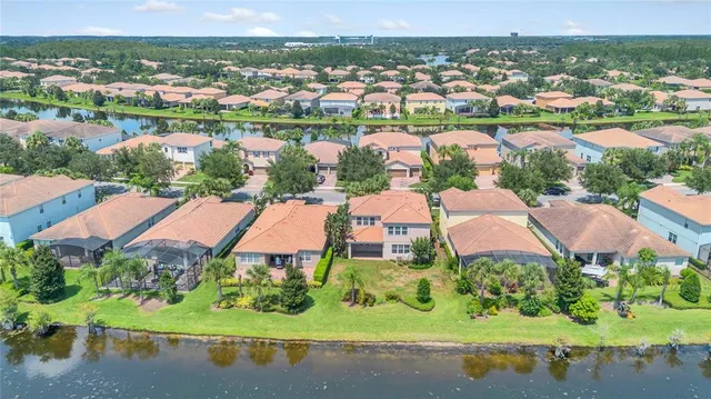 an aerial view of lake and residential houses with outdoor space
