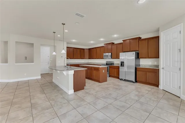 a kitchen with stainless steel appliances granite countertop a refrigerator and a sink