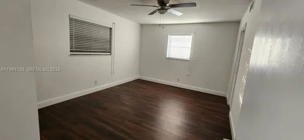 a view of a room with wooden floor and windows